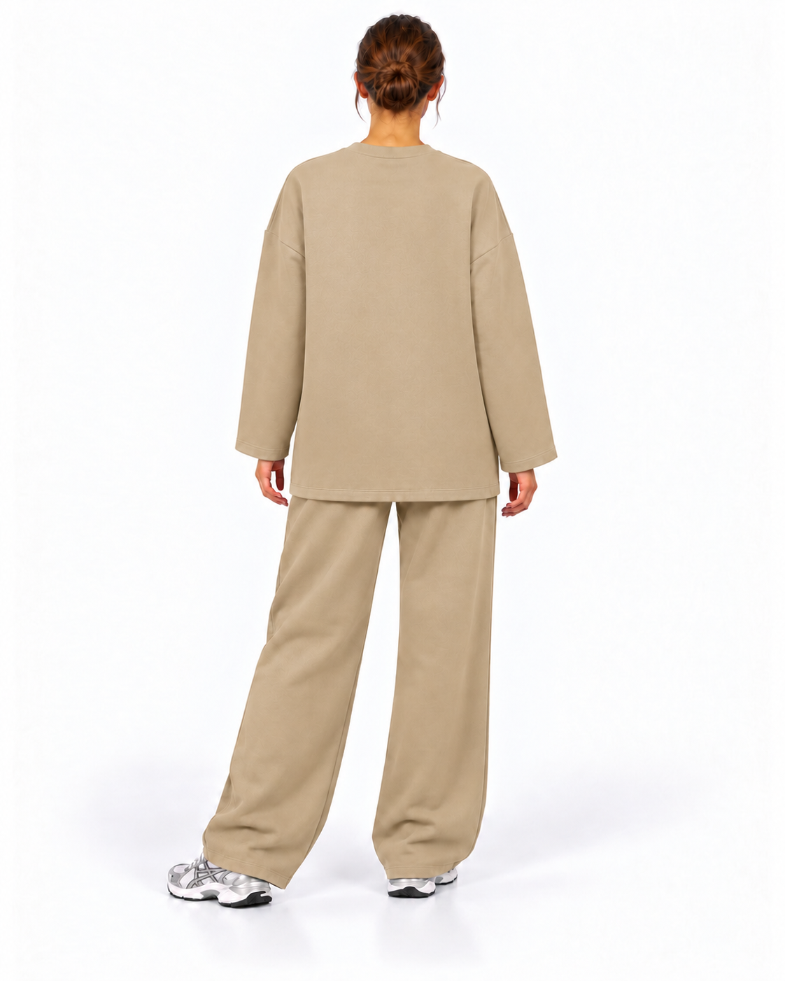 A model shown from the back wearing a matching beige long-sleeve top and wide-leg pants set, paired with white sneakers, against a plain white studio background.