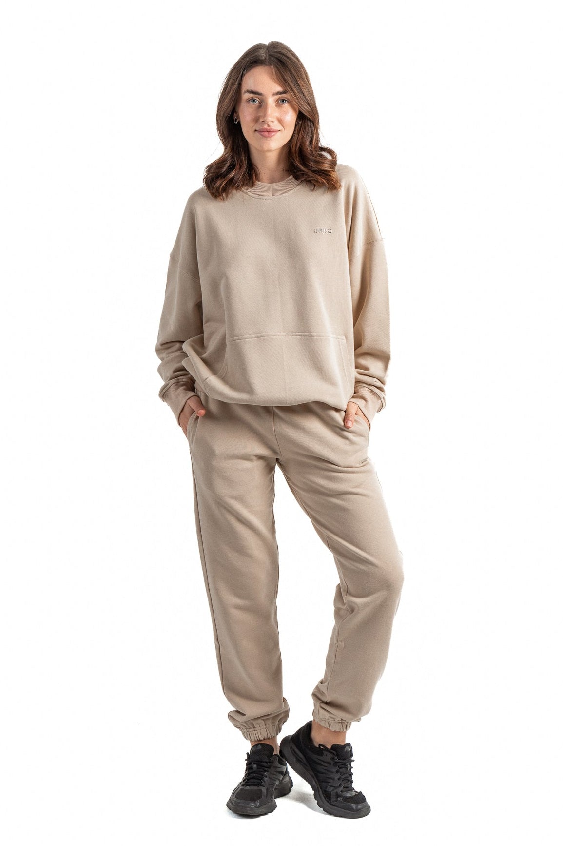 Woman wearing a beige tracksuit on a white background