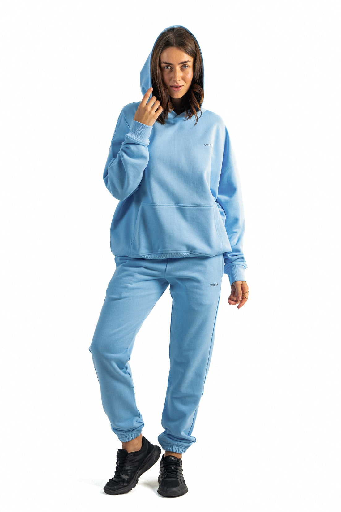 Woman wearing a light blue hoodie and pants on a white background