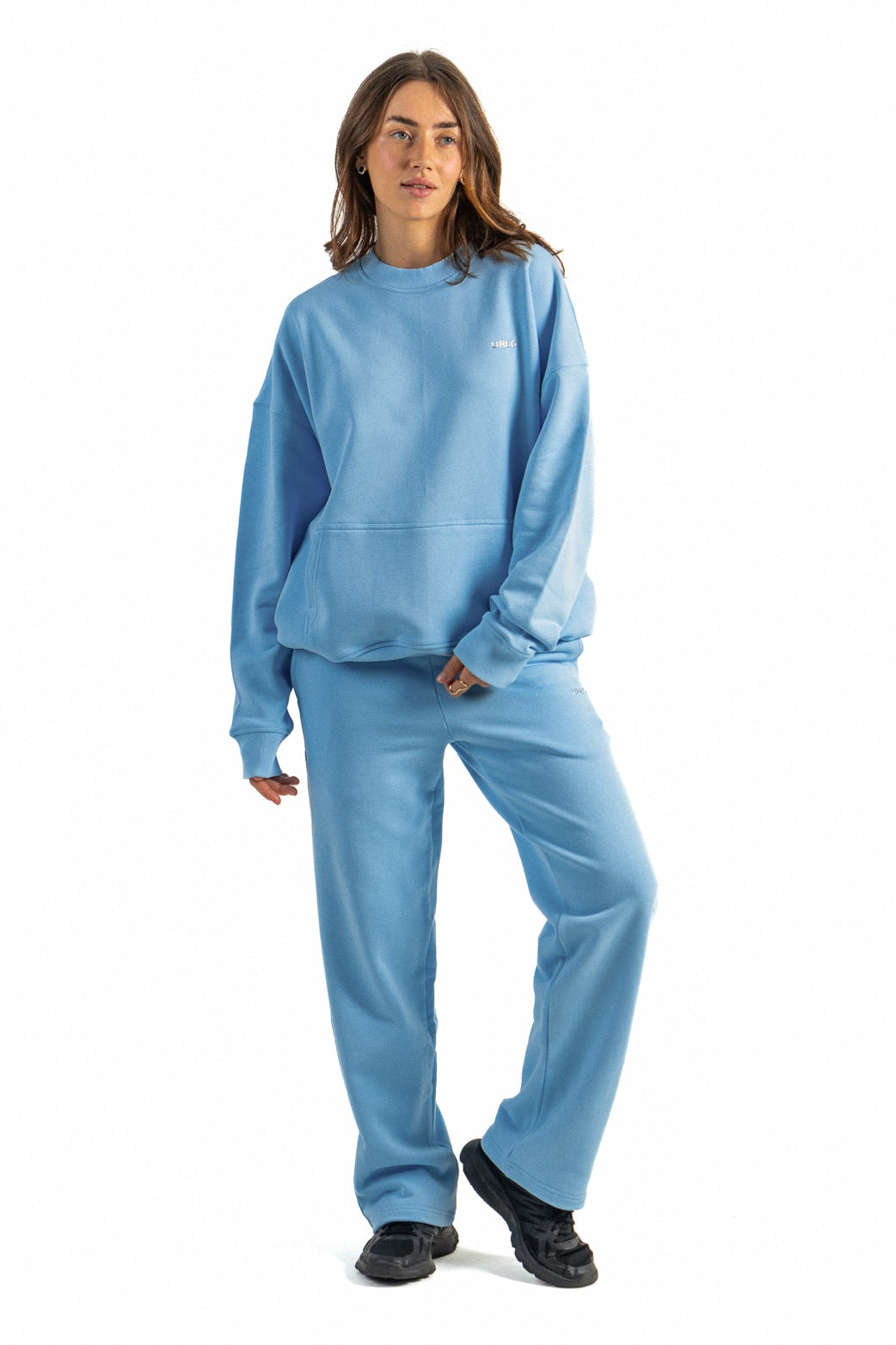 Person wearing a blue sweatshirt and pants on a white background