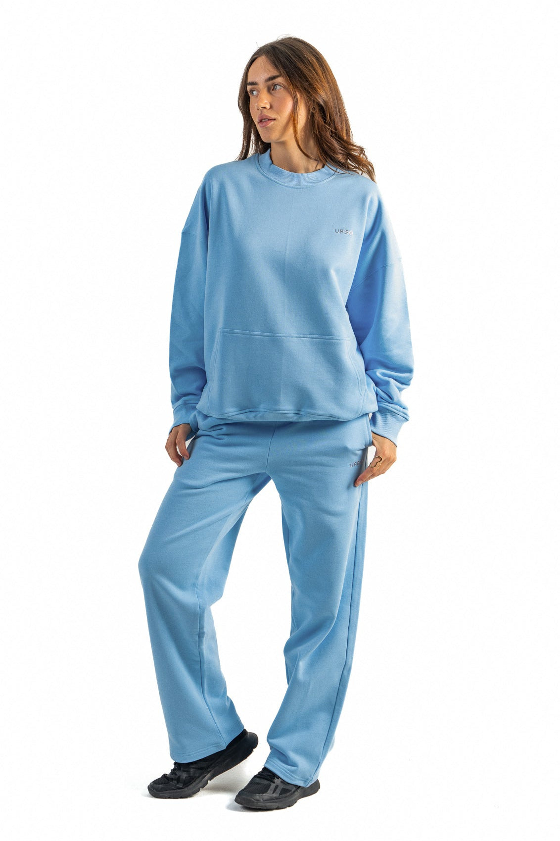 Woman wearing a light blue tracksuit on a white background