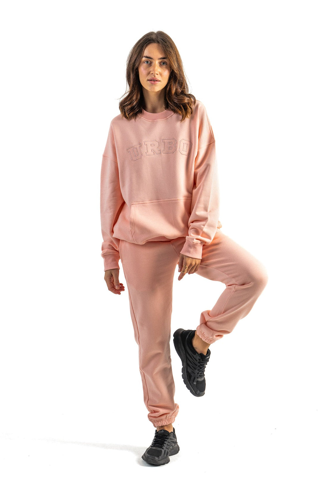 Woman wearing a pink tracksuit on a white background
