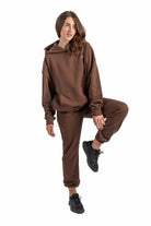 Person wearing a brown tracksuit on a white background