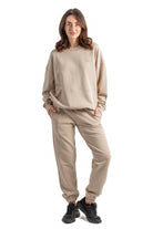Woman wearing a beige tracksuit on a white background