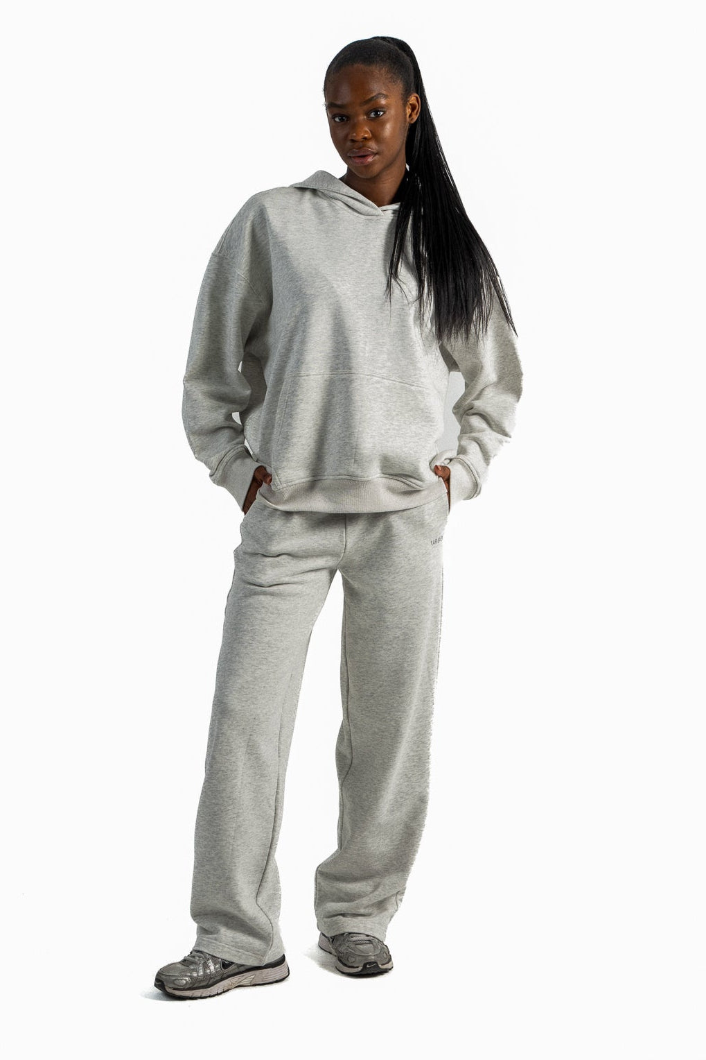 Person wearing a gray tracksuit on a white background