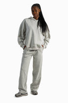 Person wearing a gray tracksuit on a white background