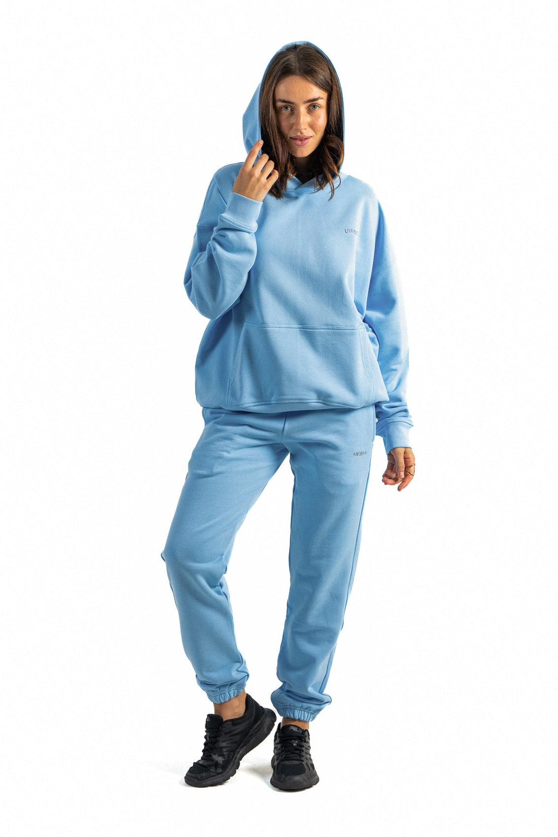 Woman wearing a light blue hoodie and pants on a white background