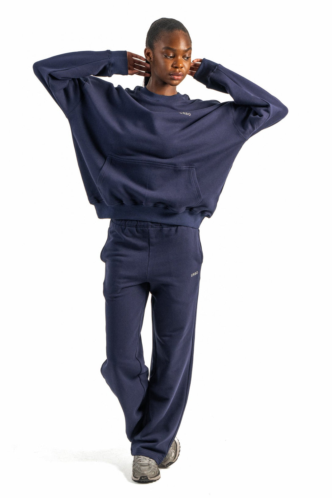 Person wearing a navy tracksuit on a white background