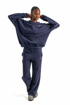 Person wearing a navy tracksuit on a white background
