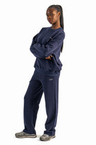 Person wearing a navy blue tracksuit on a white background
