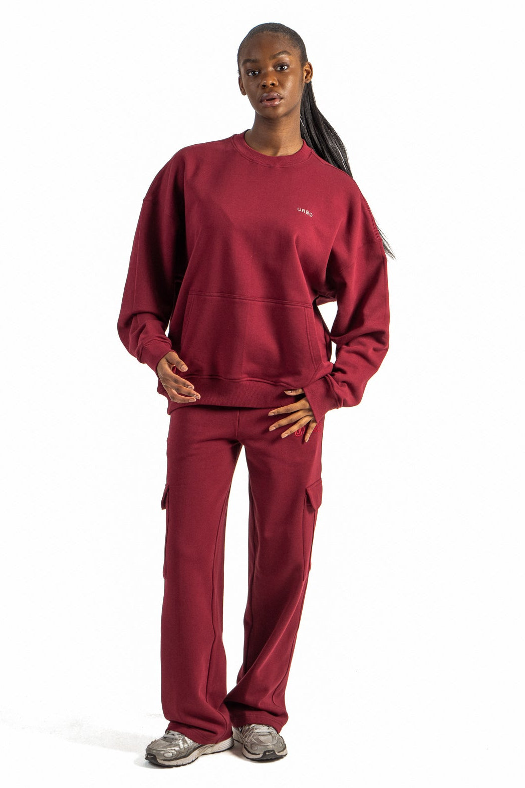 Person wearing a red sweatshirt and pants on a white background