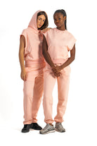 Two people wearing matching pink outfits on a white background