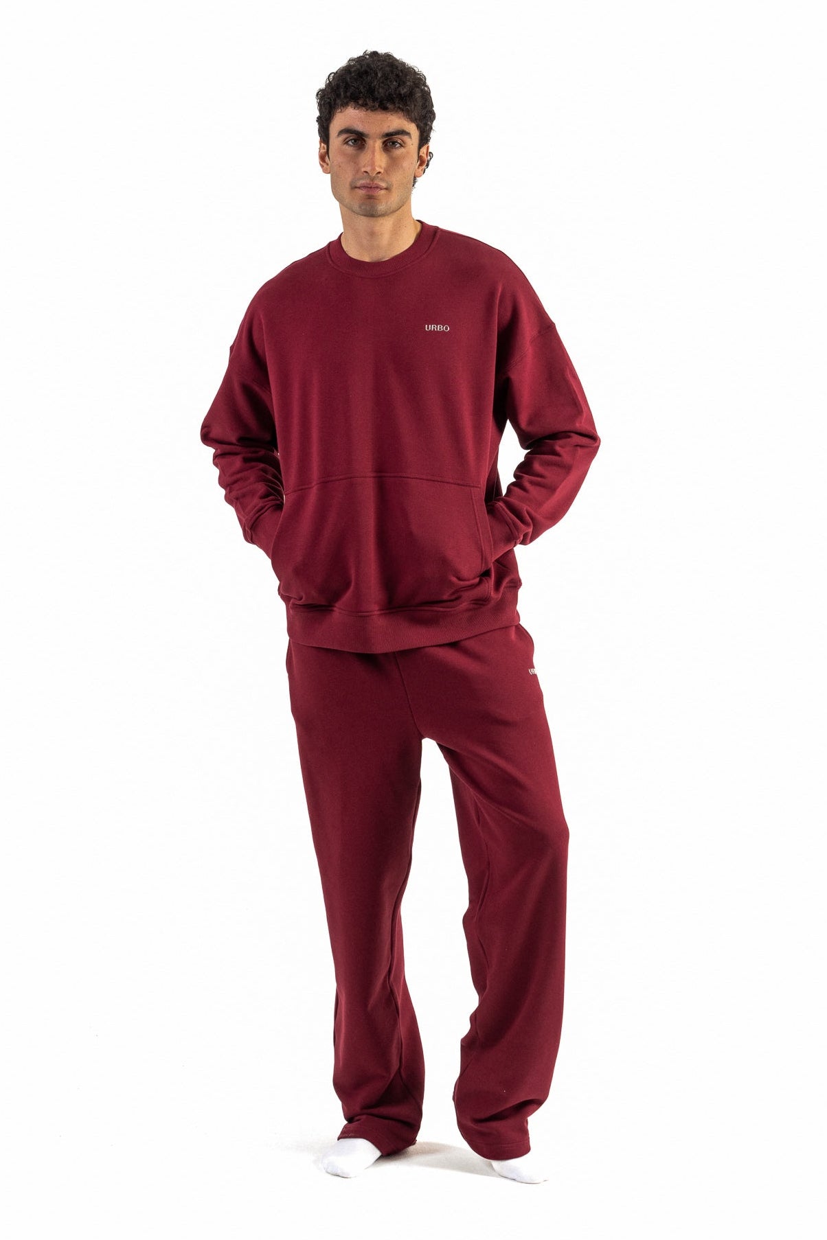 Man wearing a red sweatshirt and pants set on a white background