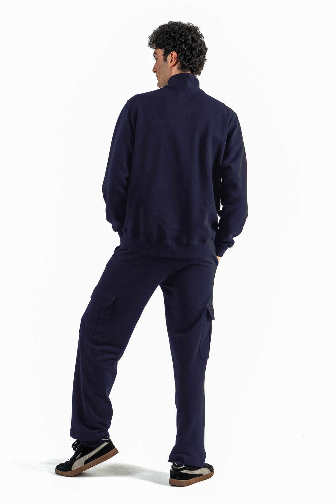 Person wearing a navy tracksuit on a white background