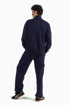 Person wearing a navy tracksuit on a white background