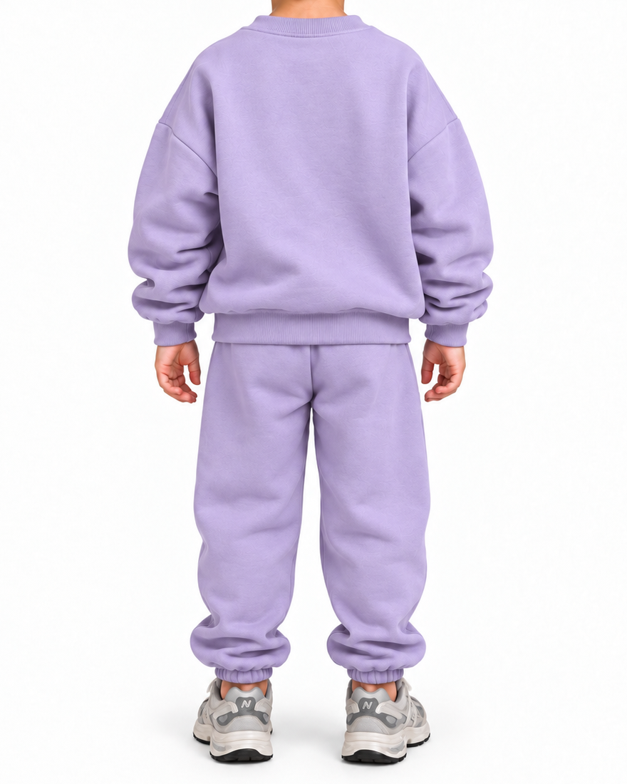 A child viewed from the back wearing a matching light purple sweatshirt and jogger pants set, paired with gray sneakers, against a plain white background.