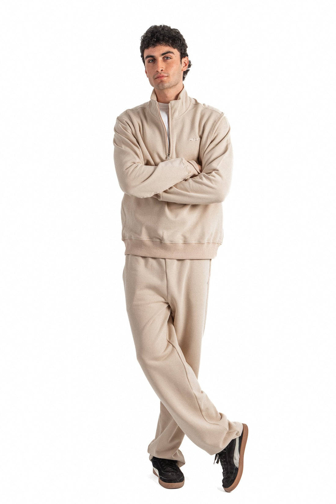Man wearing a beige tracksuit on a white background