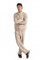 Man wearing a beige tracksuit on a white background